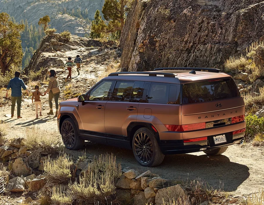 Family hiking near a Hyundai Santa Fe